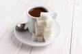 A cup of coffee and a pile of sugar cubes.