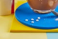 A cup of coffee and Pills of sugar substitute and natural sweetener in powder on a yellow and blue podium Royalty Free Stock Photo