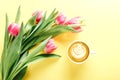 Cup of coffee and pink tulips on yellow background, top view Royalty Free Stock Photo