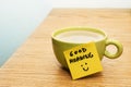 Cup of coffee, post-it note good morning and smiley