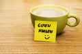 Cup of coffee, post-it note good morning and smiley