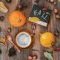 Cup of coffee, pumpkins, leaves, chestnuts, wild apples, board inscription Fall. Flat lay. Concept of autumn