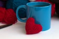 Cup of coffee with red heart of yarn with colours balls of wool yarn on white background with