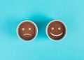 Cup of coffee with a sad and a happy face, positive and negative mindset, support and evaluation concept, emotion Royalty Free Stock Photo