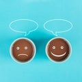 Cup of coffee with a sad and a happy face, positive and negative mindset, support and evaluation concept, speech bubble Royalty Free Stock Photo