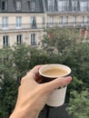 Cup of coffee in th hand with a saucer against the background Royalty Free Stock Photo