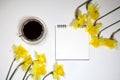 Cup of coffee and a saucer, daffodils on a white background Royalty Free Stock Photo