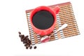 A cup of coffee and scattered coffee beans on white background