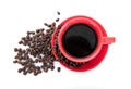 A cup of coffee and scattered coffee beans on white background