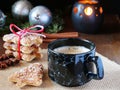 Cup of coffee served with Christmas tree shaped cinnamon biscuits in a rustic setup Royalty Free Stock Photo