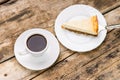 Cup of coffee with slice of cheesecake on cake server