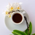 A cup of coffee and a small white orchid on a plate Royalty Free Stock Photo