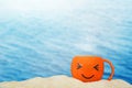 Cup of coffee smiley on sand sea background. Royalty Free Stock Photo