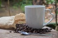 Cup of coffee with smoke and coffee beans in burlap sack on wood Royalty Free Stock Photo