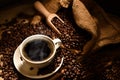 Cup of coffee with smoke and coffee beans on burlap sack Royalty Free Stock Photo