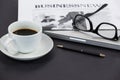 Cup of coffee, spectacles, closed laptop, newspaper and pen Royalty Free Stock Photo