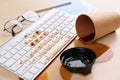 Cup of coffee spilled over computer keyboard on wooden office desk Royalty Free Stock Photo