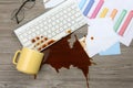 Cup of coffee spilled over computer keyboard on office desk, flat lay Royalty Free Stock Photo