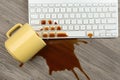 Cup of coffee spilled over computer keyboard on table, flat lay Royalty Free Stock Photo