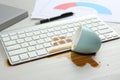 Cup of coffee spilled over computer keyboard on white table Royalty Free Stock Photo