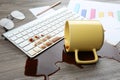 Cup of coffee spilled over computer keyboard on wooden office desk Royalty Free Stock Photo