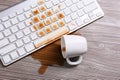 Cup of coffee spilled over computer keyboard on wooden table, flat lay Royalty Free Stock Photo