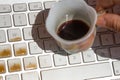 Cup of coffee spilling onto a laptop keyboard Royalty Free Stock Photo