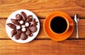 Cup of coffee with spoon and chocolate candies on table. Royalty Free Stock Photo