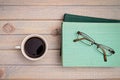 cup of coffee and a stack of books and glasses.