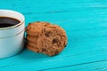 Cup of coffee & stack of sweet cookies on blue table