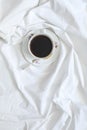 Cup of coffee standing on a white sheet