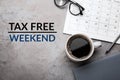 Cup of coffee, stationery and text TAX FREE WEEKEND on table, flat lay Royalty Free Stock Photo