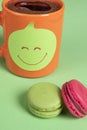 Sticky note with smiley face on a cup of coffee. Office desk with cookies and coffee