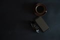 cup of coffee, sun glasses, smartphone on a black background Royalty Free Stock Photo