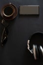 cup of coffee, sun glasses, smartphone, headphones on a black background Royalty Free Stock Photo