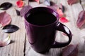 Cup of coffee surounded by red and purple fall leaves