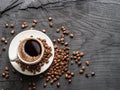 Cup of coffee surrounded by coffee beans. Top view.