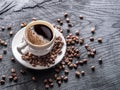 Cup of coffee surrounded by coffee beans. Top view