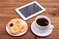 Cup of coffee and sweet cakes digital tablet