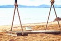 A Cup of coffee is on the swing in the morning near the beach.