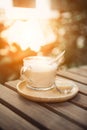 Cup of coffee on table in cafe and the sunset of sunny light