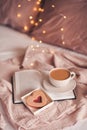 Cup of coffee with tasty heart shape cookie staying on open paper book. Valentines Day Royalty Free Stock Photo