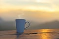 Cup coffee and tea with steam on wood table outdoor over mountains landscape with sunlight. Beauty nature background.