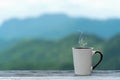 Cup coffee and tea with steam on wood table over mountains city landscape with sunlight. Royalty Free Stock Photo