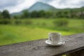 Cup of coffee or tea on a wooden table over mountains landscape and rice field with sunlight. Beauty nature background Royalty Free Stock Photo