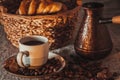 Cup of coffee on textile with beans, dark candy sugar, pots, basket and cake Royalty Free Stock Photo