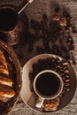 Cup of coffee on textile with beans, dark candy sugar, pots, basket and cake Royalty Free Stock Photo