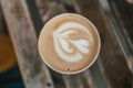 Cup of coffee to go on the wooden table with latte art. Street coffee, top view. Royalty Free Stock Photo