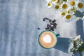 A cup of coffee top view on blue vintage with daisies flower background Royalty Free Stock Photo