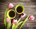 Cup of coffee, tulip on wooden background